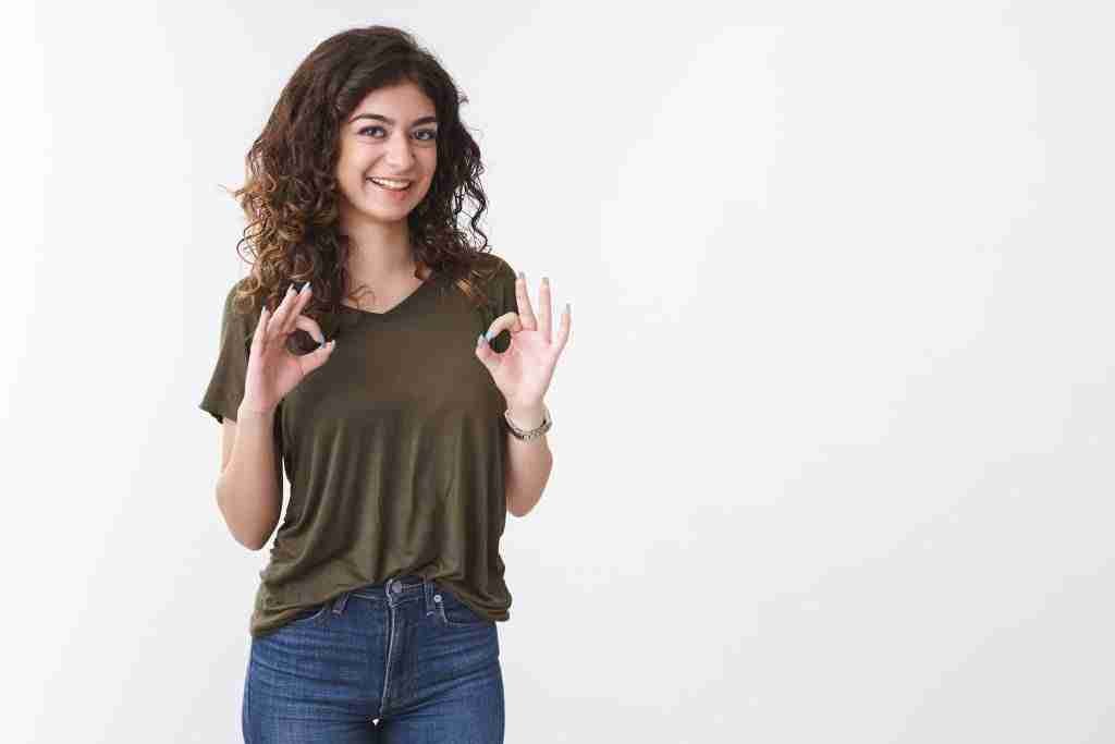 ok count done portrait charming devious young armenian girlfriend affirm everything goes fine show okay gesture smiling positive agree give approval standing white background