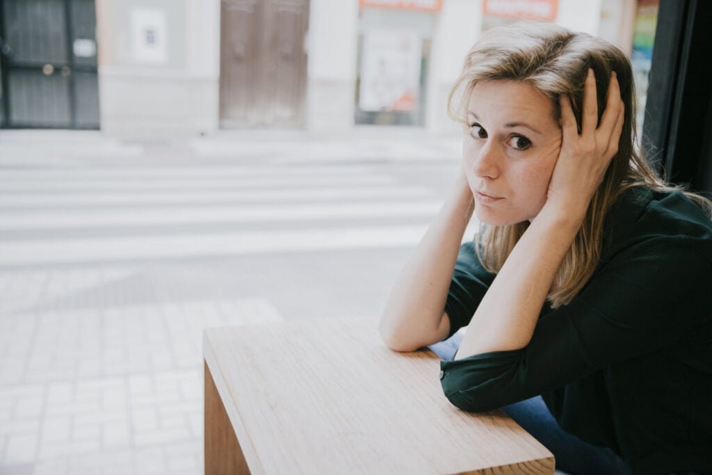How to Practice Self-Love in the Face of Societal Pressure 3 A young woman feeling exhausted by the societal pressure
