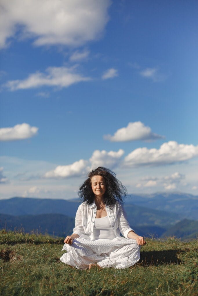 A mature woman meditating out in the open