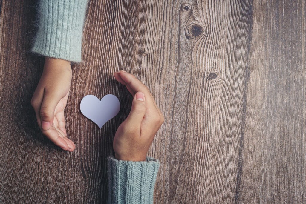 The Role of Forgiveness in Clearing Blockages to Manifestation 4 paper heart and couple's hands on wooden table