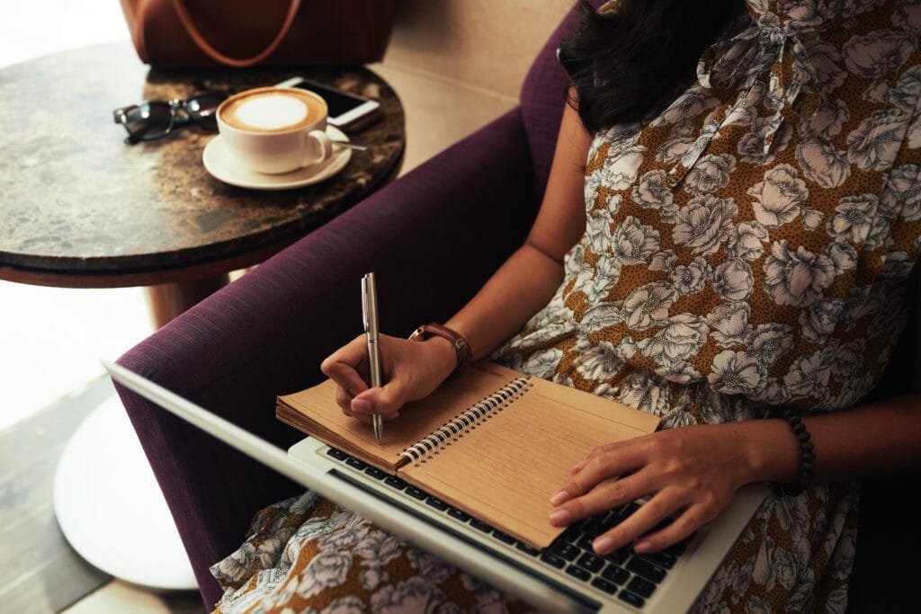 The Power of Scripting in the Law of Attraction - Manifesting Your Dream Life 5 Woman reading something on laptop and writing down important thoughts