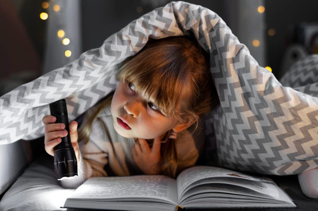 A girl reading a book before going to sleep as a bedtime routine