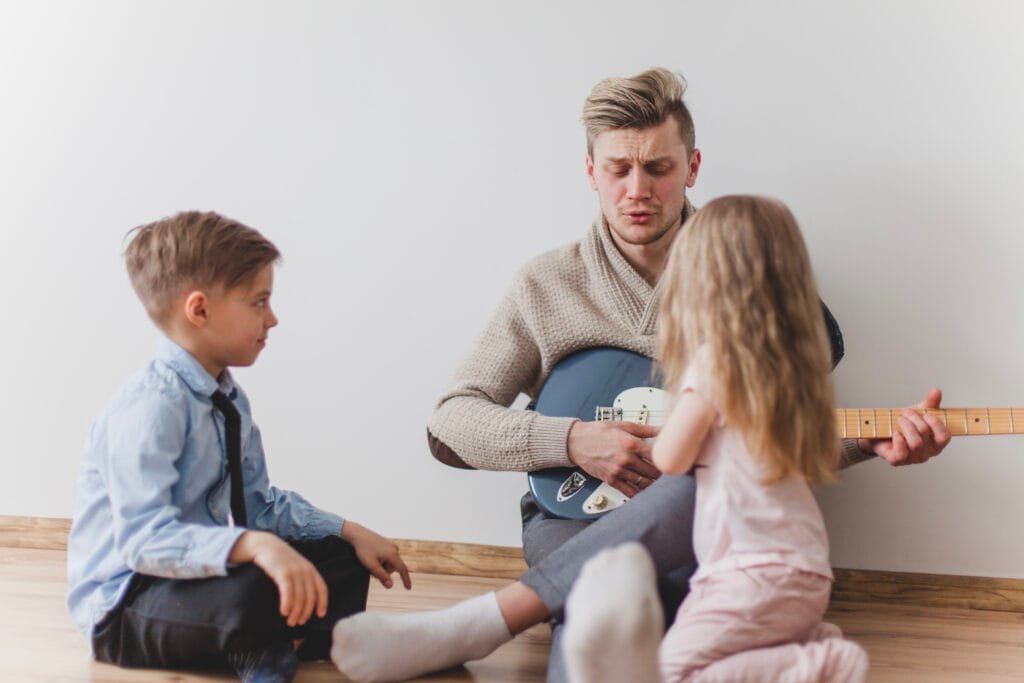 9 Simple Mindful Parenting Exercises for Daily Connection - A Complete Guide 3 A father playing guitar, singing and having mindful time with his children
